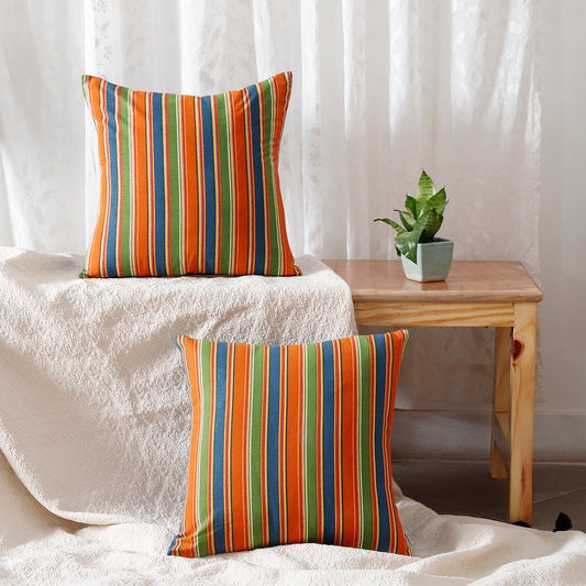 Two comfy pillows, one orange and one green, with stripes like a zebra.