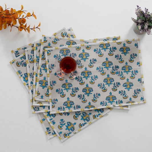 A set of 6 beige cotton placemats with a sky blue and yellow motif print.