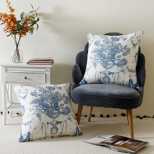 Two blue and white flower-patterned throw pillows on a wooden table.