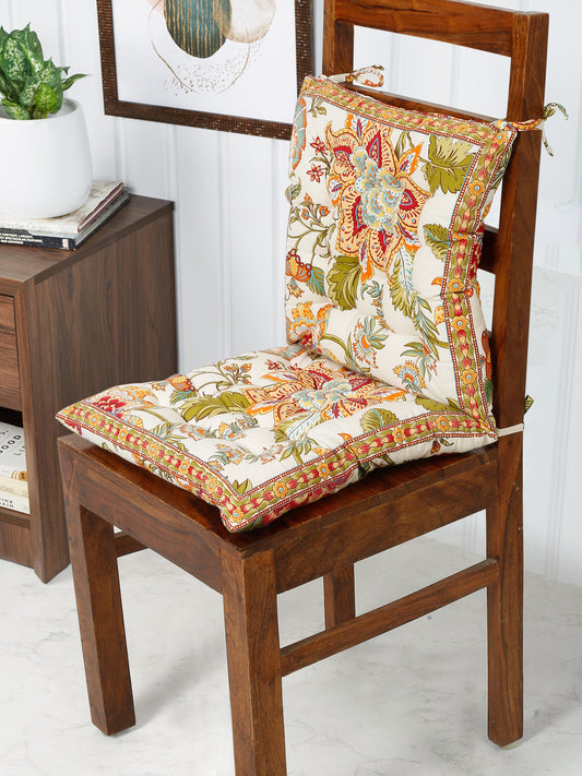 A cozy wooden chair upholstered with a cheerful floral print fabric cushion.